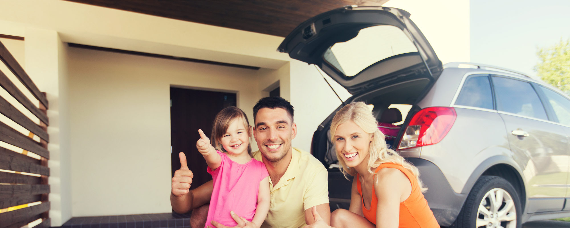 A happy family packing their car for a road trip.