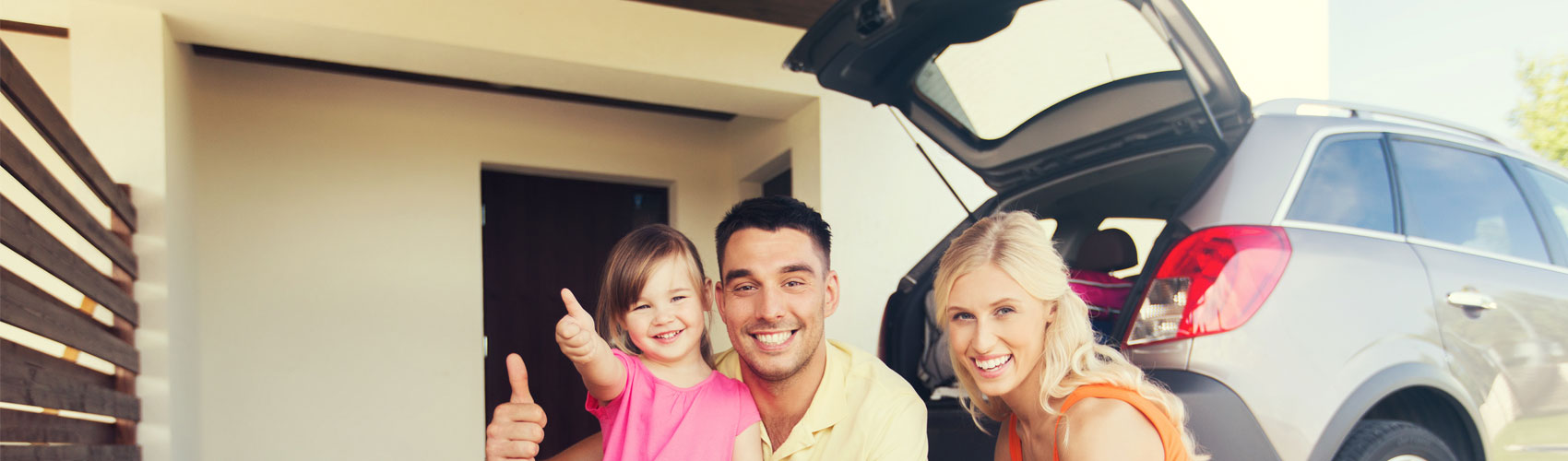 A happy family packing their car for a road trip.